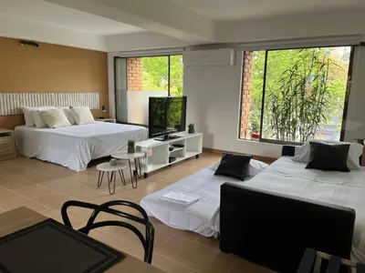 a hotel room with two beds and a tv at Poblado Park Aparta Estudio in El Poblado