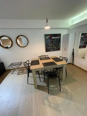 a dining room with a table and chairs and two mirrors at Poblado Park Aparta Estudio in El Poblado