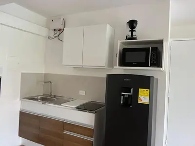 a small kitchen with a black refrigerator and a microwave at Poblado Park Aparta Estudio in El Poblado