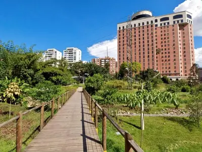 a wooden boardwalk in a city with a tall building at Poblado Park Aparta Estudio in El Poblado