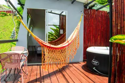 a hammock on the deck of a house at La Paloma Glamping in Palestina