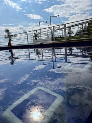 a reflection of a bridge in a pool of water at La Paloma Glamping in Palestina