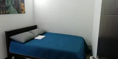 a small bedroom with a bed with a blue blanket at Apartamento vista piscina principal in Santa Fe de Antioquia