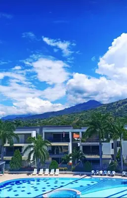 a resort with a swimming pool and palm trees at Apartamento vista piscina principal in Santa Fe de Antioquia
