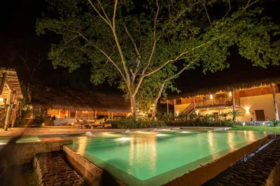 a swimming pool at night in a resort at Nativa Refugio Escondido in Santa Fe de Antioquia