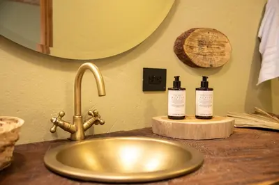 a bathroom counter with a sink and two bottles of soap at Nativa Refugio Escondido in Santa Fe de Antioquia