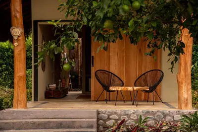 two chairs and a table in front of a door at Nativa Refugio Escondido in Santa Fe de Antioquia