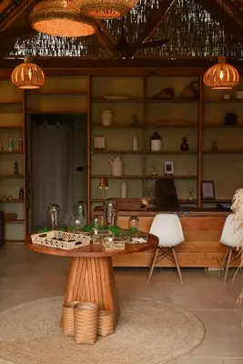 a living room with a table and chairs and chandeliers at Nativa Refugio Escondido in Santa Fe de Antioquia