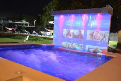 a swimming pool with a lit up sign next to it at VILLA ALEJANDRIA - CABAÑA LAMARIQUITA-CABAÑA ORQUIDEA-CABAÑA CARAMBOLa in Mariquita
