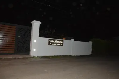 a white fence with a sign on it at night at VILLA ALEJANDRIA - CABAÑA LAMARIQUITA-CABAÑA ORQUIDEA-CABAÑA CARAMBOLa in Mariquita