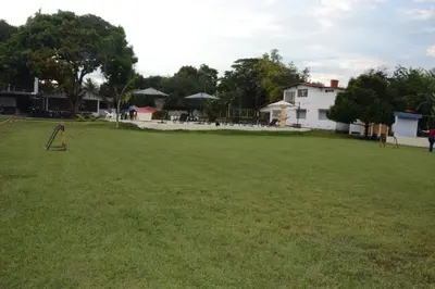 a large grassy field with a house in the background at VILLA ALEJANDRIA - CABAÑA LAMARIQUITA-CABAÑA ORQUIDEA-CABAÑA CARAMBOLa in Mariquita