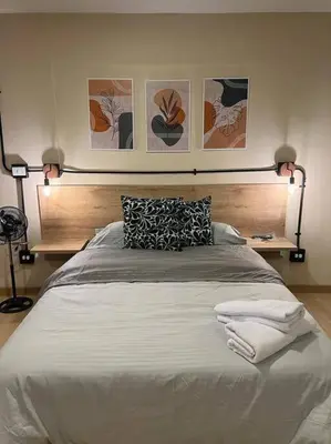 a bedroom with a large white bed with two lamps at Hospedaje en Medellí cerca a Laureles NID103 By Roots Rentals in Medellín