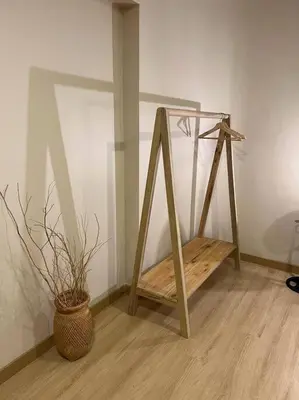a wooden stand next to a vase with a plant at Hospedaje en Medellí cerca a Laureles NID103 By Roots Rentals in Medellín