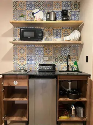 a kitchen with a stove and a counter top at Hospedaje en Medellí cerca a Laureles NID103 By Roots Rentals in Medellín