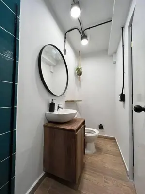 a bathroom with a sink and a mirror and a toilet at Hospedaje en Medellí cerca a Laureles NID103 By Roots Rentals in Medellín