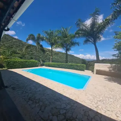 a swimming pool in a yard with palm trees at ENTREPALMAS in San Jerónimo