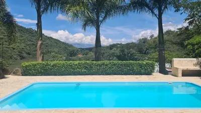 a blue swimming pool with palm trees in the background at ENTREPALMAS in San Jerónimo