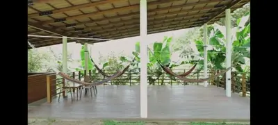 a deck with chairs and hammocks under a pergola at ENTREPALMAS in San Jerónimo