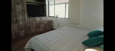 a bedroom with a bed with green pillows and a tv at ENTREPALMAS in San Jerónimo