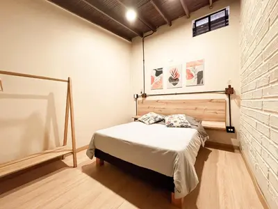 a bedroom with a bed and a brick wall at Alojamiento económico en Medellín - NID104 By Roots Rentals in Medellín