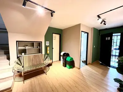 a living room with a couch in a room with green walls at Alojamiento económico en Medellín - NID104 By Roots Rentals in Medellín