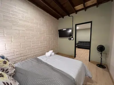 a bedroom with a bed and a wall with a mirror at Alojamiento económico en Medellín - NID104 By Roots Rentals in Medellín