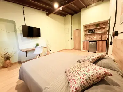 a bedroom with a large bed and a desk at Apartamento amoblado asiste a Guns N Roses NID201 By Roots Rentals in Medellín