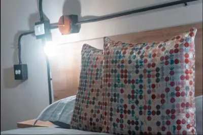 a bed with a pillow and a lamp on it at Apartamento amoblado asiste a Guns N Roses NID201 By Roots Rentals in Medellín