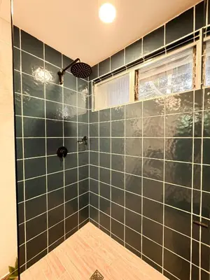 a bathroom with a shower with green tiled walls at Apartamento amoblado asiste a Guns N Roses NID201 By Roots Rentals in Medellín
