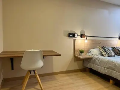 a bedroom with a desk and a bed with a chair at Amoblado cerca Centro eventos la Macarena NID203 By Roots Rentals in Medellín