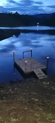 a dock in the middle of a lake at night at Finca El Peñol in Guatapé