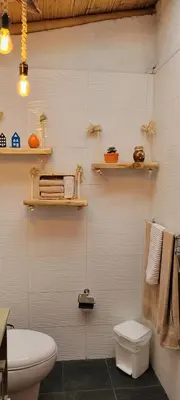 a bathroom with a toilet and shelves on the wall at Finca El Peñol in Guatapé