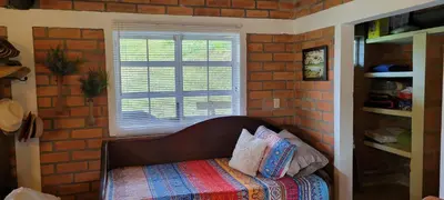 a bed in a room with a brick wall at Finca El Peñol in Guatapé