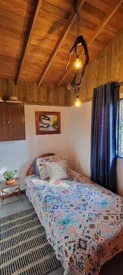 a bedroom with a bed and a wooden ceiling at Finca El Peñol in Guatapé
