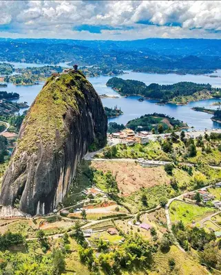 an aerial view of a large rock island in a river at Noches de Guatapulco in Guatapé