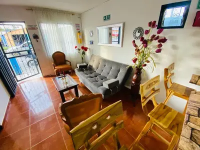 a living room with a couch and a table and chairs at Noches de Guatapulco in Guatapé