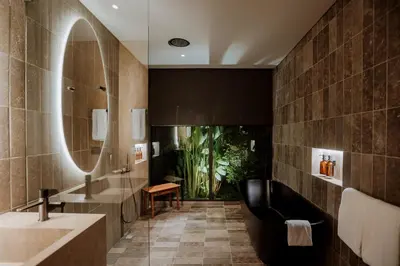 a bathroom with a large mirror and a tub at Hotel El Zarzo in Medellín