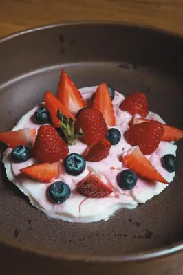 a dessert with strawberries and blueberries and whipped cream at Hotel El Zarzo in Medellín