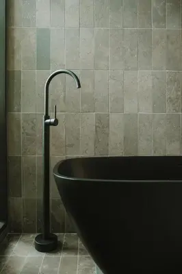 a bath tub with a faucet in a bathroom at Hotel El Zarzo in Medellín