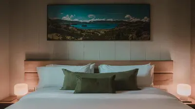 a bedroom with a bed with white sheets and pillows at Hotel El Zarzo in Medellín