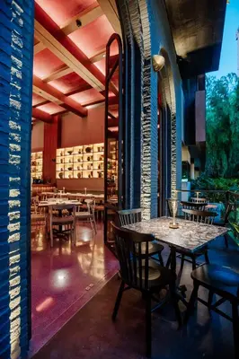 a restaurant with tables and chairs in a room at Hotel El Zarzo in Medellín
