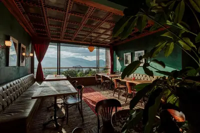 a restaurant with tables and chairs and a large window at Hotel El Zarzo in Medellín