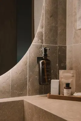 a bottle of soap sitting on a shelf in a bathroom at Hotel El Zarzo in Medellín