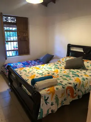 a bed with a comforter and a laptop on it at Casa Rustica con chimenea en su interior, rodeado de los cuatro elementos tierra, fuego, aire y agua, ubicada en sector tranquilo, para descansar en familia o amigos, in Mazo