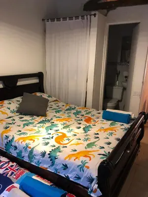 a bedroom with a bed with a comforter with birds on it at Casa Rustica con chimenea en su interior, rodeado de los cuatro elementos tierra, fuego, aire y agua, ubicada en sector tranquilo, para descansar en familia o amigos, in Mazo