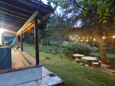 a garden at night with a table and benches at Casa Rustica con chimenea en su interior, rodeado de los cuatro elementos tierra, fuego, aire y agua, ubicada en sector tranquilo, para descansar en familia o amigos, in Mazo