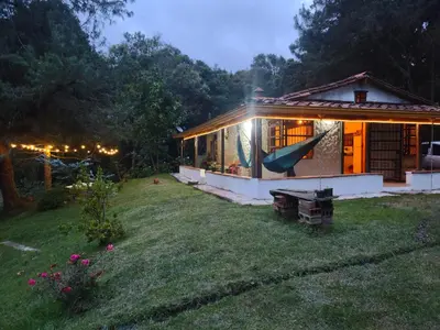 a small house with a slide in the yard at Casa Rustica con chimenea en su interior, rodeado de los cuatro elementos tierra, fuego, aire y agua, ubicada en sector tranquilo, para descansar en familia o amigos, in Mazo