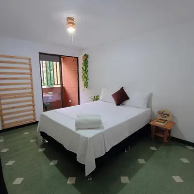 a bedroom with a large white bed in a room at Moradia Laureles Medellin in Medellín