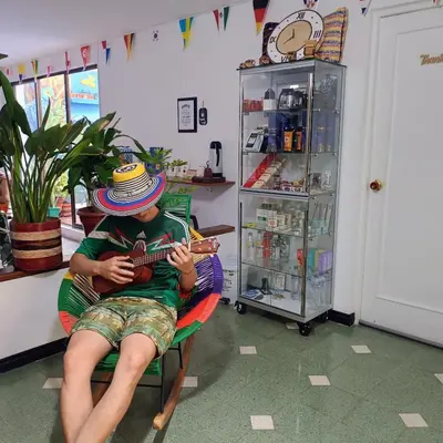 a man sitting in a chair playing a guitar at Moradia Laureles Medellin in Medellín