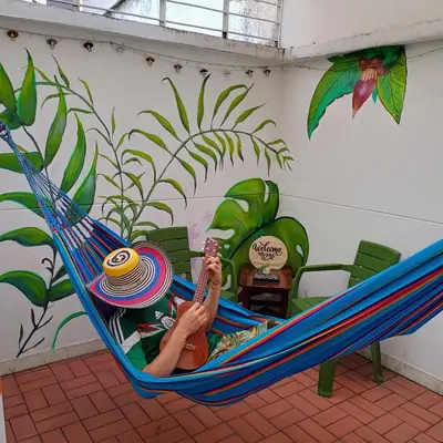 a woman laying in a hammock in a room at Moradia Laureles Medellin in Medellín